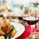 Glass of red wine beside a roasted turkey on a dinner table